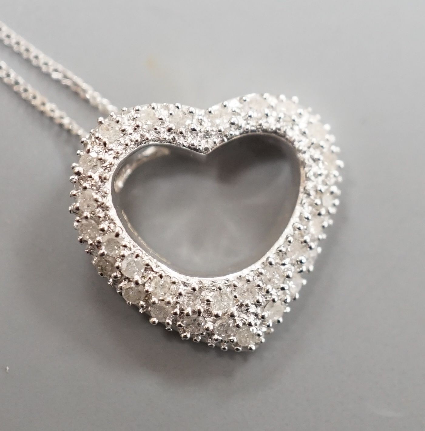 A modern 375 white metal and diamond chip set open work heart shaped pendant, 15mm, on a375 fine link chain, 40cm, gross weight 2.6 grams